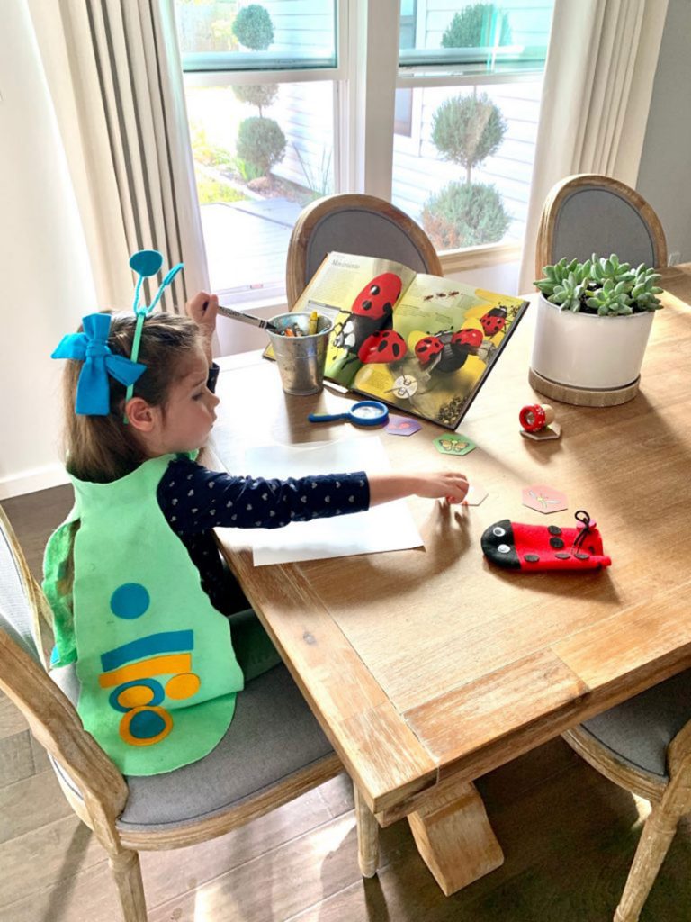 girl dressed as butterfly crafting at table