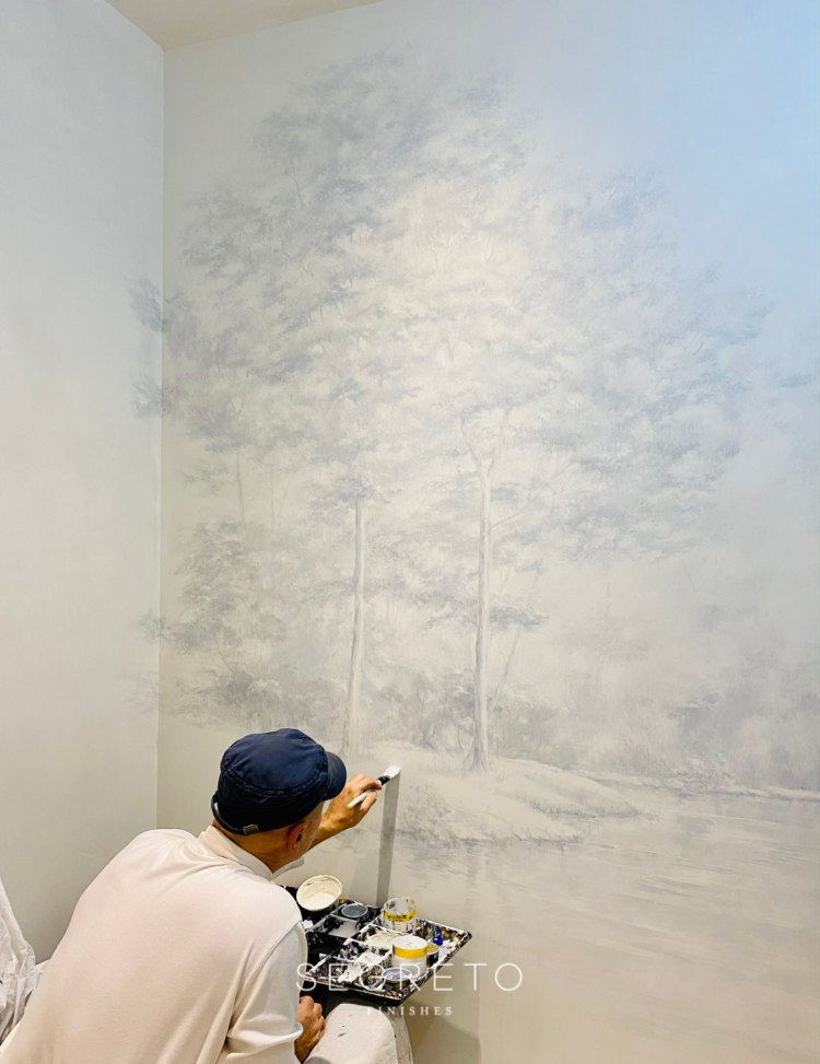 Muralist working on a mural applied over plaster