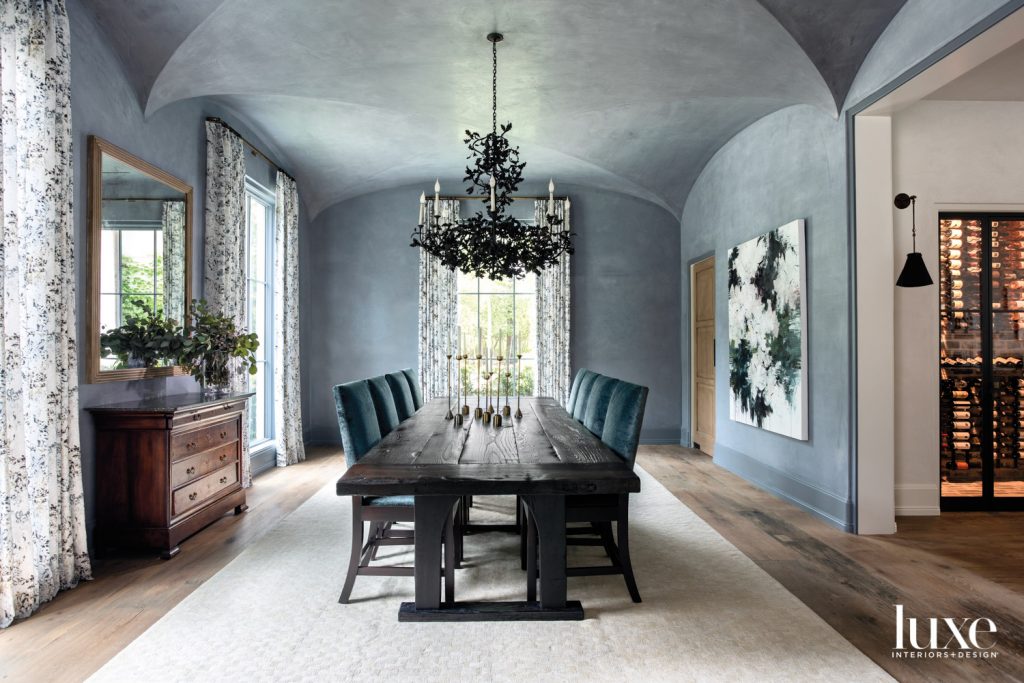 Carlos Ramirez art from Dimmitt Contemporary Art and Romo fabric draperies from Culp Associates punctuate plaster dining room walls by Segreto Finishes. A branchy chandelier from Cox London anchors a custom walnut dining table and chairs in Rose Tarlow velvet from David Sutherland. The rug is Retorra.