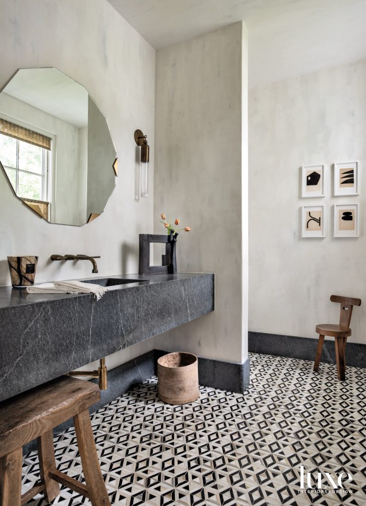 The formal powder bathroom’s Liaison by Kelly Wearstler Mosaics flooring from Ann Sacks echoes art by Michelle Avi a from M. Naeve. A Rocky Mountain faucet from Fixtures & Fittings, Apparatus sconce and Egg Collective mirror overlook a floating soapstone sink from Arizona Tile.